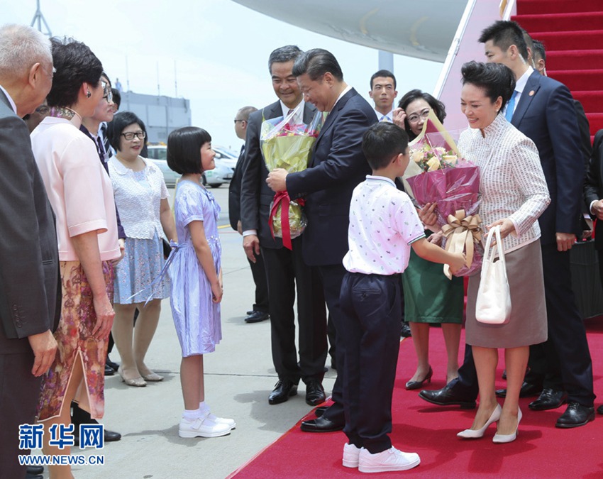 這是習(xí)近平和夫人彭麗媛在舷梯旁接受兩名香港少年敬獻(xiàn)鮮花。新華社記者 蘭紅光 攝