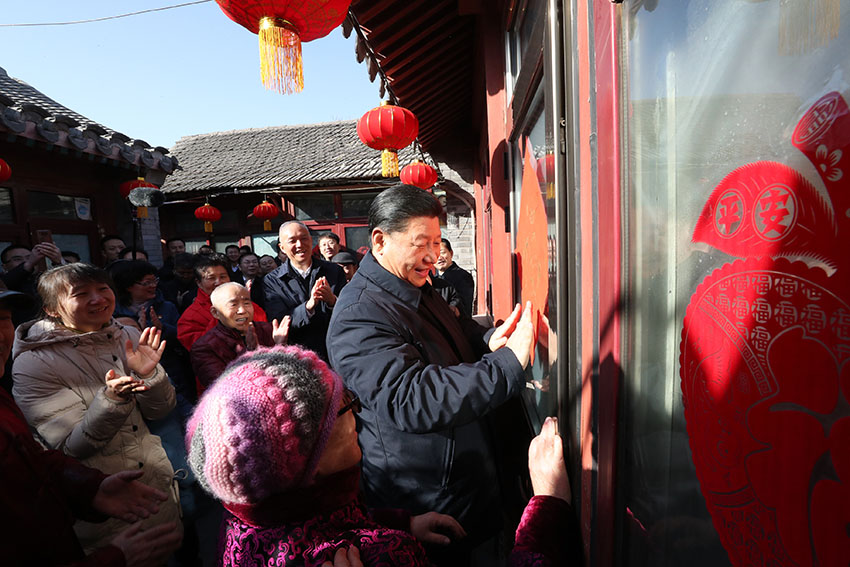 2月1日，中共中央總書記、國家主席、中央軍委主席習近平在北京看望慰問基層干部群眾，考察北京冬奧會、冬殘奧會籌辦工作。這是1日上午，習近平在前門東區(qū)草廠四條胡同32號院，高興地拿起一幅“?！弊?，親自貼到門上，給這裡的老街坊們拜年。 新華社記者 鞠鵬 攝