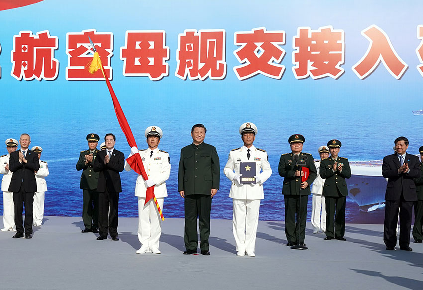 12月17日，我國第一艘國產(chǎn)航空母艦山東艦在海南三亞某軍港交付海軍。中共中央總書記、國家主席、中央軍委主席習近平出席交接入列儀式並登艦視察。這是習近平向海軍接艦部隊授予軍旗、命名証書。 新華社記者 李剛 攝