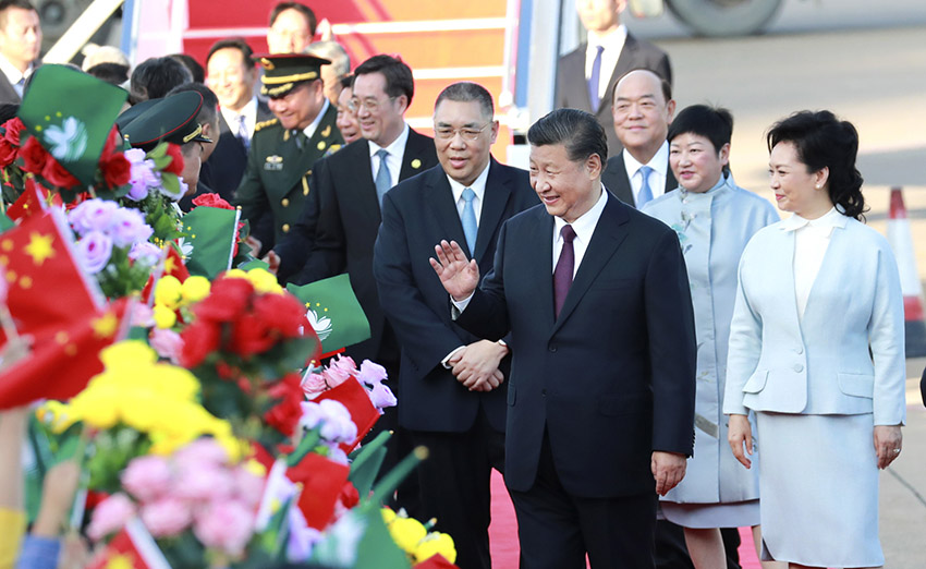 12月18日，中共中央總書記、國家主席、中央軍委主席習近平乘專機抵達澳門，出席將於20日舉行的慶祝澳門回歸祖國20周年大會暨澳門特別行政區(qū)第五屆政府就職典禮並視察澳門。這是習近平和夫人彭麗媛向歡迎人群致意。 新華社記者 龐興雷 攝